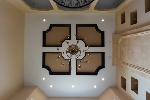 Kingfogl custom home coffered ceiling with chandelier and dark trim inlays