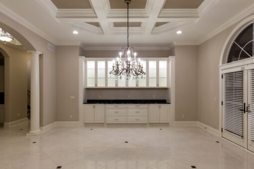 Vizzini dining room with chandelier and lit glass cabinetry