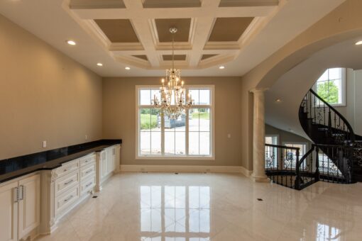 Kingfogl custom home dining room with coffered ceiling and view to a spiral staircase