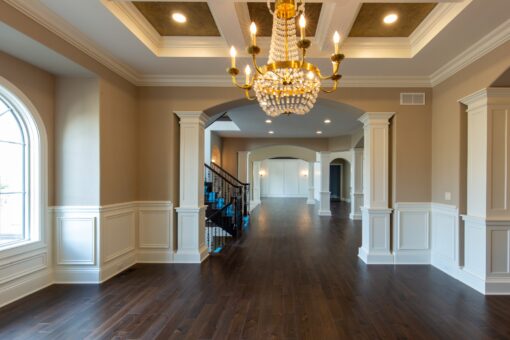 Kingfogl custom home dining room with crystal chandelier, wainscoting and columns