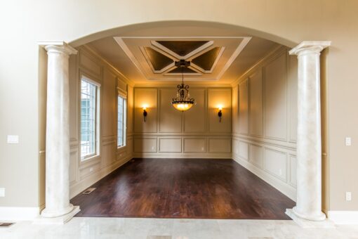 Kingfogl custom home dining room framed by columns with paneled walls