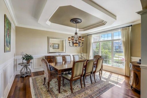 Kingfogl custom home dining room with tray ceiling, wainscoting and chandelier