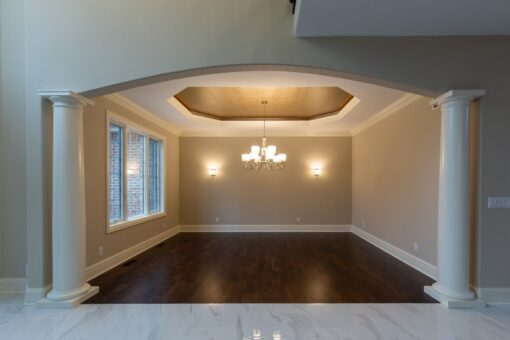 Woodview dining room with tray ceiling and columns