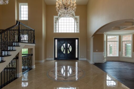 Stone Creek foyer with round-top entry doors and chandelier