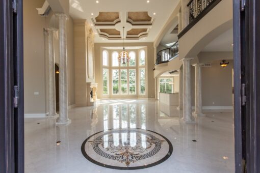 Kingfogl custom home foyer with marble medallion, coffered ceiling and window wall