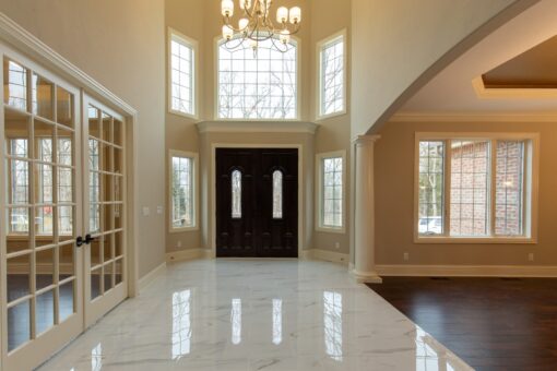 Woodview two-story foyer with marble floor and entry doors