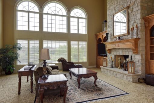 Kingfogl custom home great room with arched window wall and stone fireplace