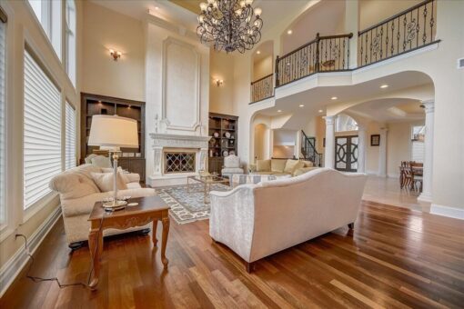 Kingfogl custom home great room with balcony above, built-ins and chandelier