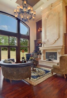 Kingfogl custom home great room with cast stone fireplace and arched windows