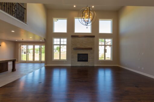 Kingfogl custom home two-story great room with stone fireplace and window wall