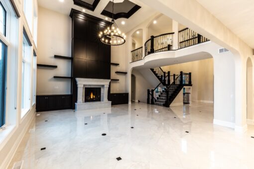Kingfogl custom home great room with black fireplace wall and spiral staircase