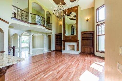 Kingfogl custom home great room with balcony, mirrored overmantel and wood floors
