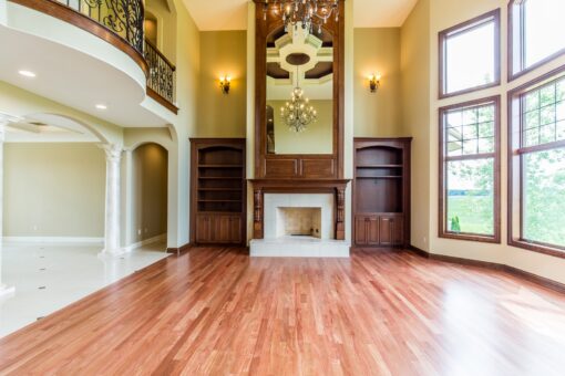Kingfogl custom home two-story great room with mirrored overmantel and arched balcony