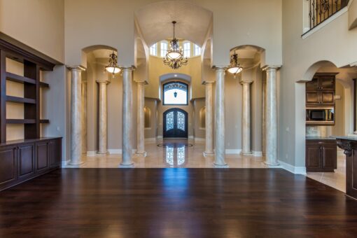 Kingfogl custom home great room view through columns to arched iron entry doors