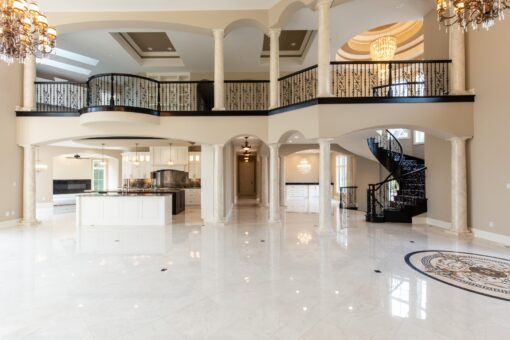 Kingfogl custom home great room with curved balcony, spiral staircase and view to the kitchen