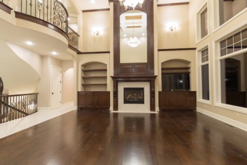 Kingfogl custom home two-story great room with dark fireplace surround and balcony