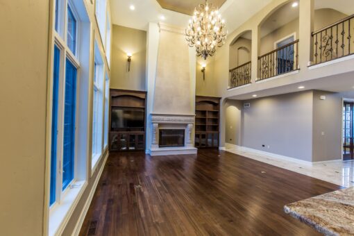 Kingfogl custom home two-story great room with fireplace and iron balcony
