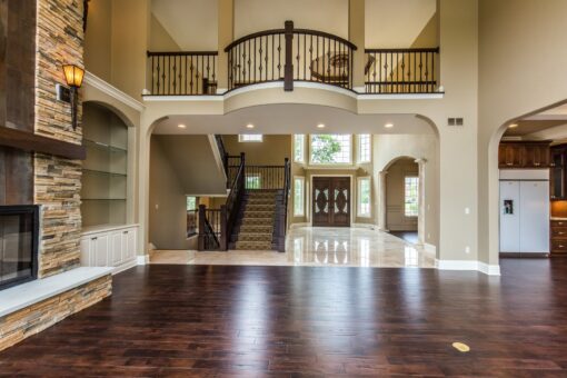 Kingfogl custom home great room with stone fireplace and balcony above the foyer