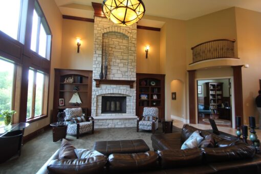 Kingfogl custom home great room with stacked stone fireplace and leather seating