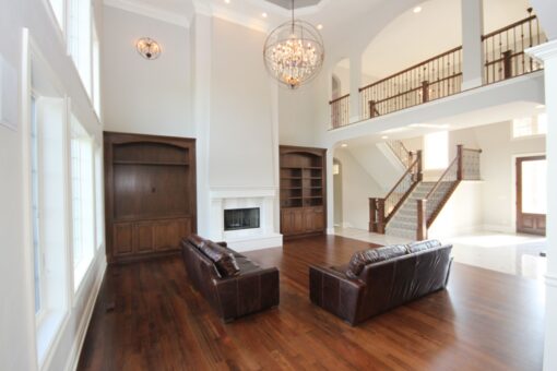 Kingfogl custom home great room with built-ins, fireplace and open staircase