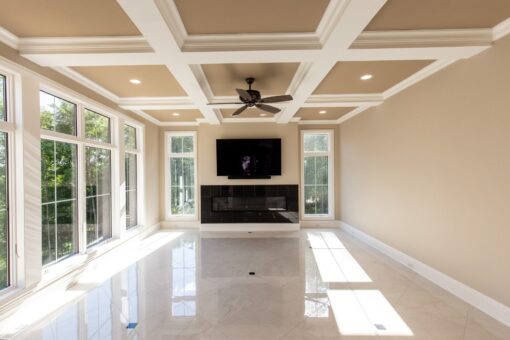 Kingfogl custom home hearth room with coffered ceiling, linear fireplace and window wall