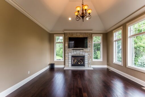Kingfogl custom home hearth room with stone fireplace, chandelier and windows