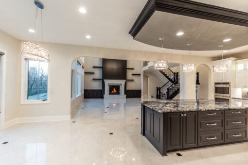 Kingfogl custom home kitchen with dark island and view to the great room fireplace