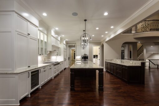 Kingfogl custom home white kitchen with dark island and view to the balcony