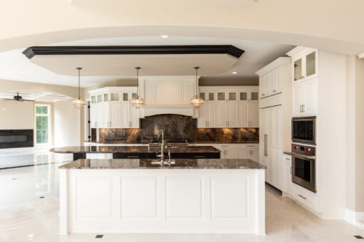 Kingfogl custom home white kitchen with dark granite backsplash and tray ceiling