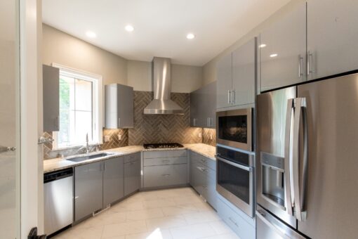 Kingfogl custom home kitchen with gray cabinetry and herringbone backsplash