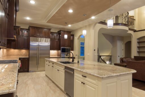 Kingfogl custom home kitchen with dark cabinetry, white island and view to the balcony