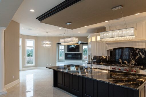 Kingfogl custom home kitchen with black marble island and crystal pendants