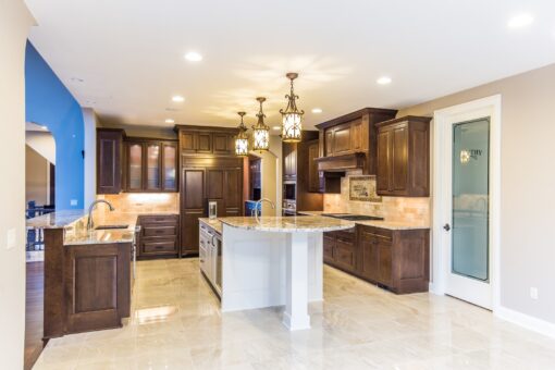Kingfogl custom home kitchen with dark wood cabinetry and white island
