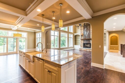 Kingfogl custom home kitchen island with granite top and view to the great room