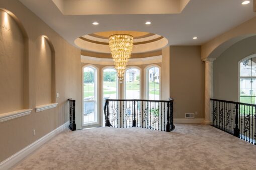 Kingfogl custom home loft with crystal chandelier and arched windows