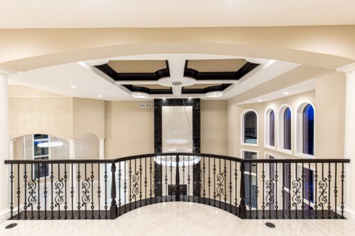 Kingfogl custom home loft overlooking the great room with iron railing and coffered ceiling