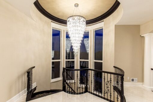 Kingfogl custom home upper landing with crystal chandelier and tall arched windows