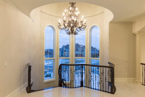 Callista loft with chandelier and two-story arched windows