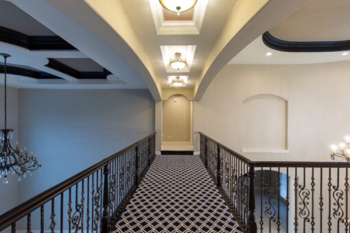 Vizzini upper hallway with iron railing and patterned carpet