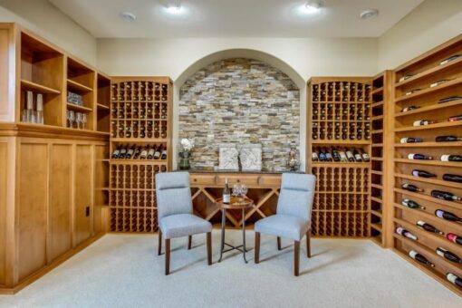 Kingfogl custom home wine cellar with wood racks and stone accent wall
