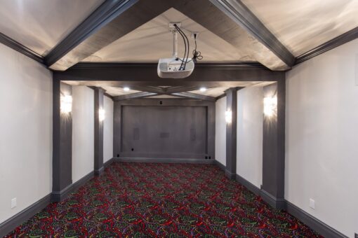 Woodview lower-level home theater with dark beams