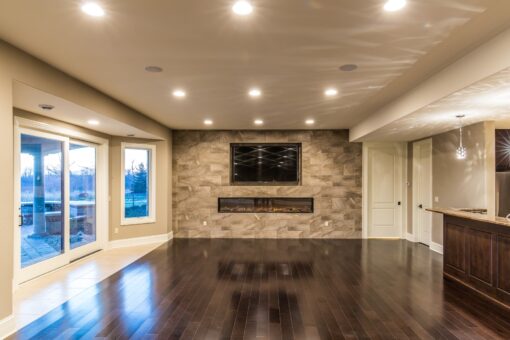 Presidio lower-level family room with stone fireplace wall