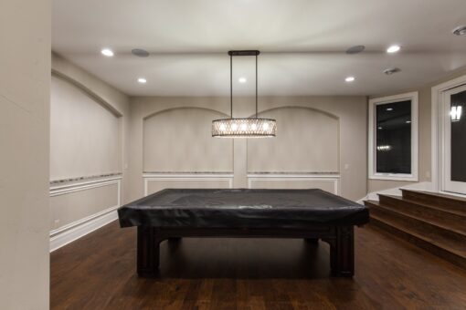 Kingfogl custom home lower-level game room with pool table and stepped platform