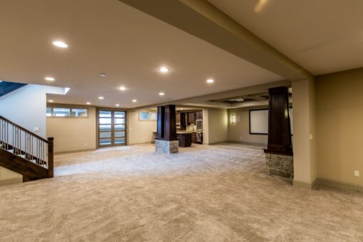 Kingfogl custom home lower level with stone-base columns and staircase