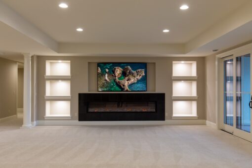 Vizzini lower-level family room with linear fireplace and lit niches