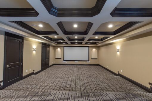 Kingfogl custom home lower-level home theater with coffered ceiling and patterned carpet