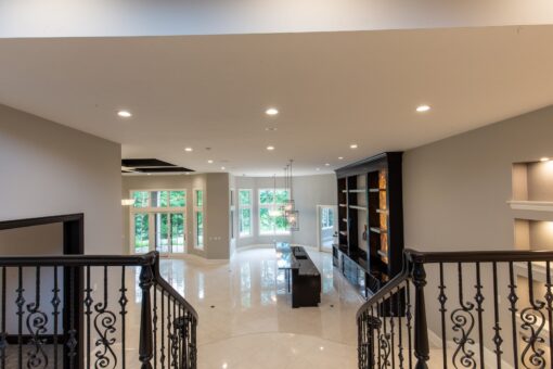 Kingfogl custom home lower level viewed from the iron staircase with built-ins