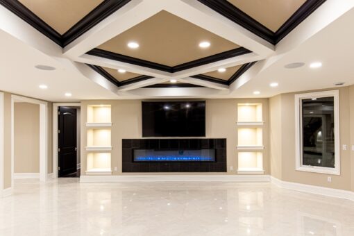 Kingfogl custom home lower-level family room with linear fireplace and coffered ceiling