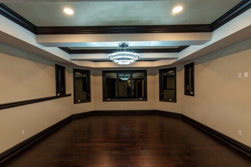 Kingfogl custom home lower-level room with coffered ceiling and dark wood floors