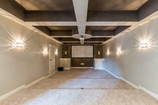 Kingfogl custom home lower-level theater room with coffered ceiling and sconces